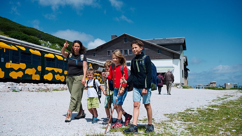 Unternehmen Sie direkt vom Bergbahnhof aus atemberaubende Wanderungen., © NB/Wegerbauer Familie geht an Salamanderzug vorbei