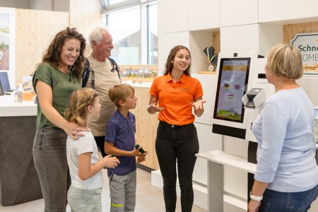 Gro&szlig;eltern, Enkelkinder und Mutter werden von Mitarbeiterin beraten